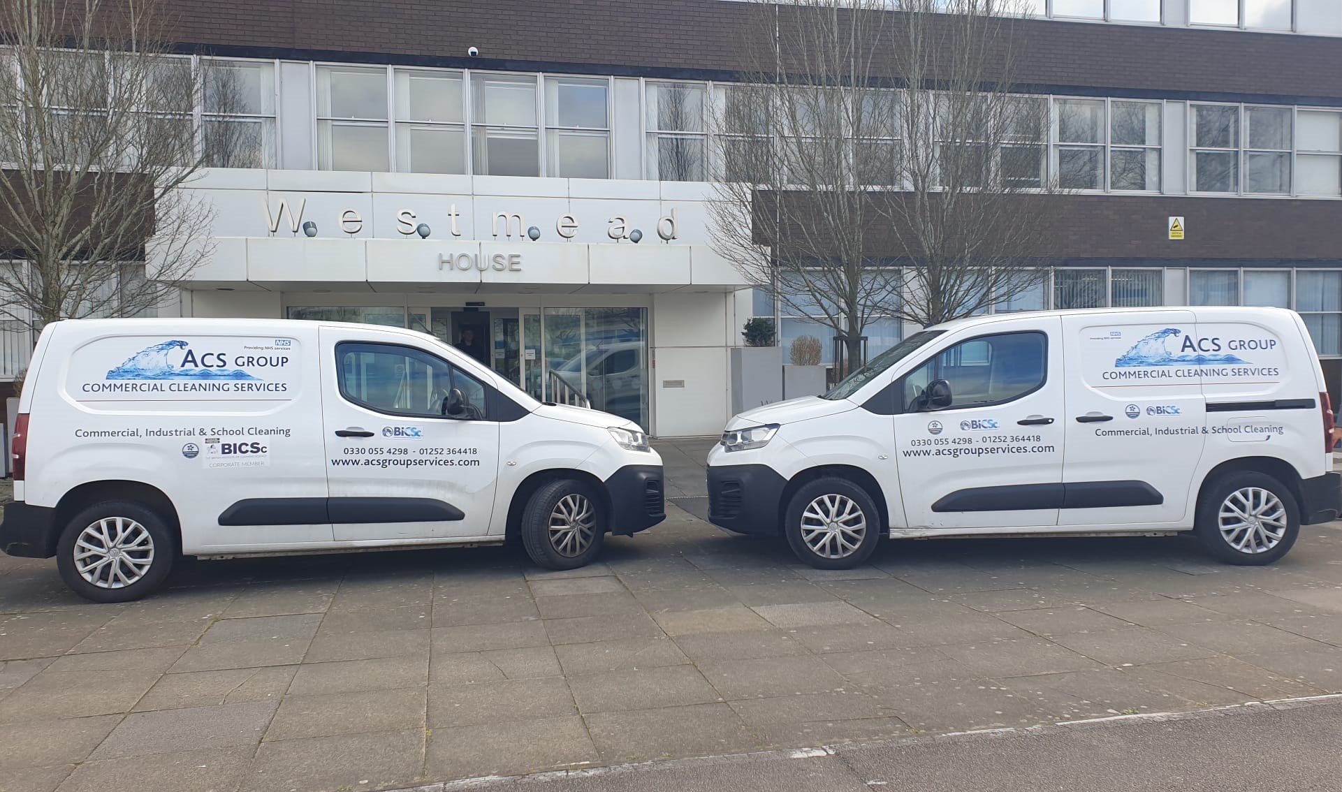 2 ACS group vans parked outside front office